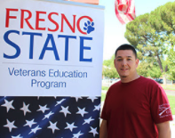 Joe Greene standing in front of veterans education program banner