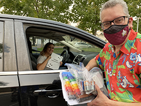 Man Posing by Car with Collected Supplies
